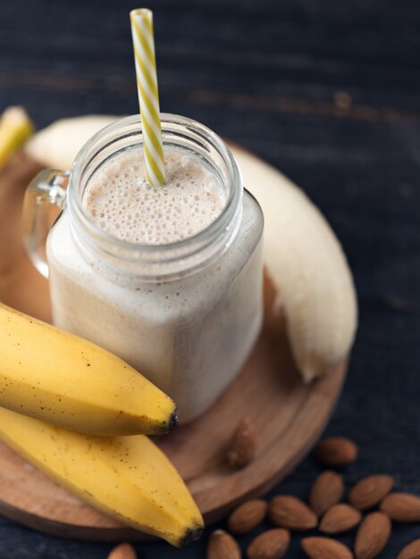 Frullato di banana fresca su un tavolo di legno in un barattolo