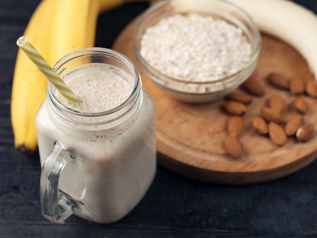 Frullato di banana fresca su un tavolo di legno in un barattolo