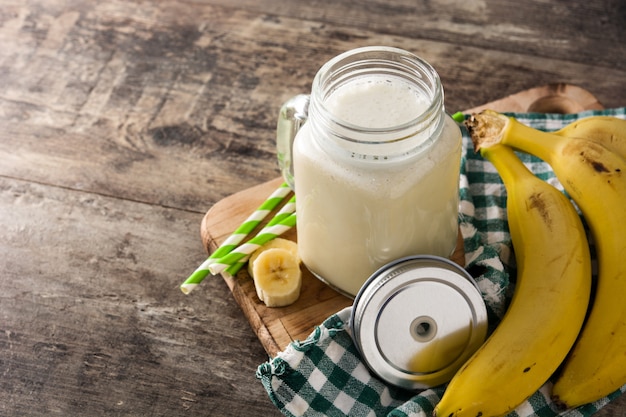 Frullato di banana in barattolo sul tavolo di legno