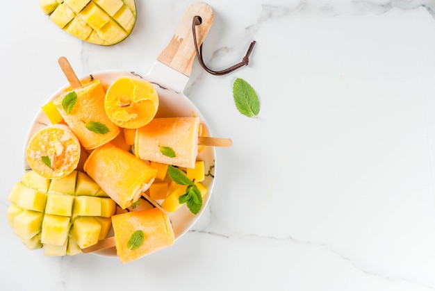 Frullato di mango congelato, con foglie di menta e frutta fresca di mango