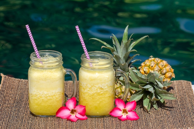 Frullato di mango e ananas fatto in casa con latte di cocco in due tazze di vetro