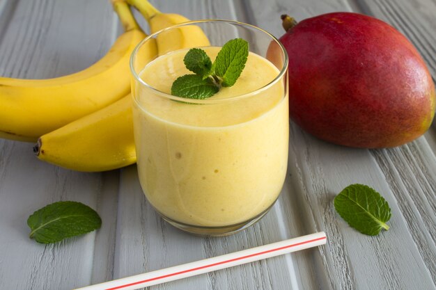 Frullato di mango e banana sul legno grigio