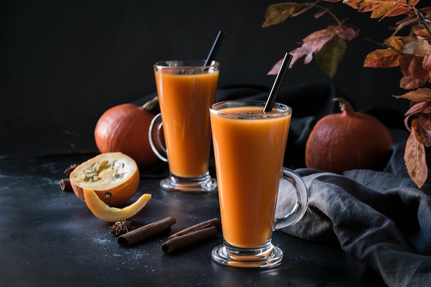 Frullato di spremuta fresca della zucca o succo su oscurità. Autunno, autunno o inverno bevanda calda sul buio.