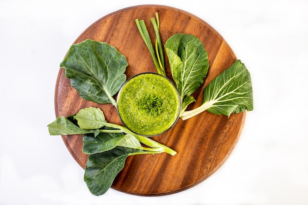 Frullato di verdure verde sano in un bicchiere isolato su sfondo bianco del tavolo