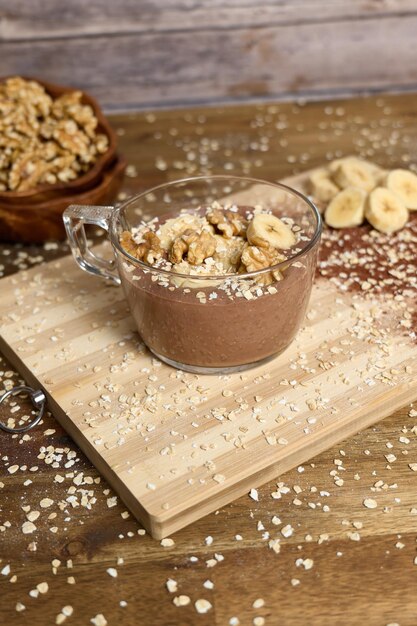 Frullato sano con banana e cacao su sfondo marrone