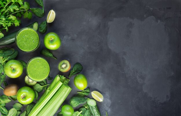 Frullato verde biologico fresco con ingredienti su sfondo grigio cemento. Vista dall'alto. Copiare l'area dello spazio.