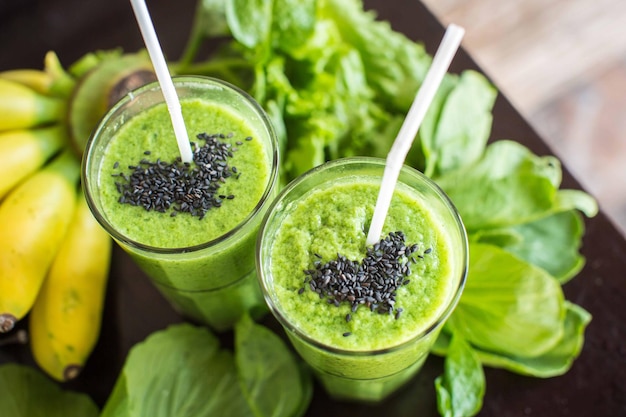 Frullato verde fresco con banana e spinaci con cuore di semi di sesamo Amore per un sano concetto di cibo crudo