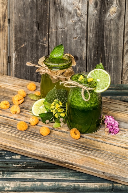 frullato verde in un barattolo con lime, kiwi e bacche