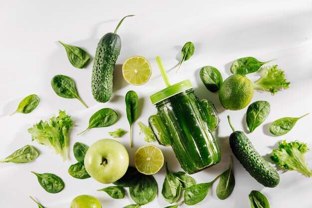 frullato verde in un grazioso vasetto di vetro a forma di cactus con spinaci e frutta e verdura verdi