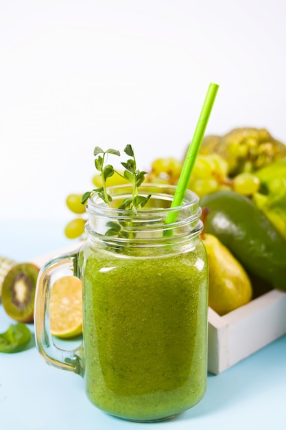 Frullato verde mescolato fresco in barattolo di vetro con frutta e verdura. Concetto di salute e disintossicazione.