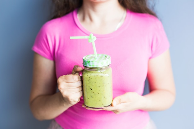 Frullato verde sano con asparagi in mano della donna. Stile di vita vegano, crudo, detox e dietetico.
