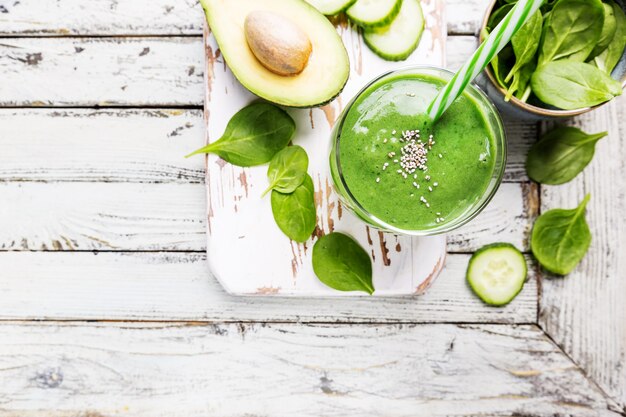 Frullato verde sano con banana avocado spinaci e semi di chia su bianco