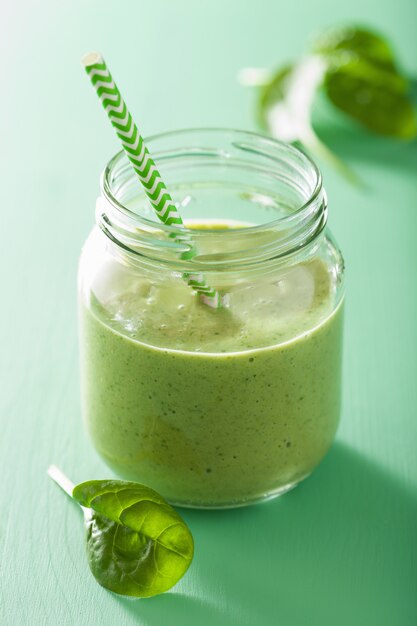 Frullato verde sano con banana di mango di spinaci in barattolo di vetro