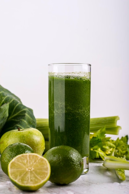 Frullato verde sano con paglia in una tazza del barattolo su fondo bianco. Copia spazio.