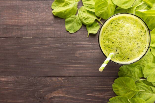 Frullato verde sano su fondo di legno rustico