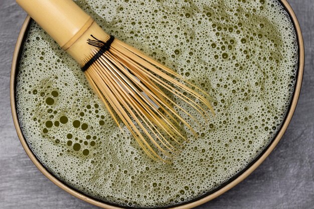 Frusta di bambù in una ciotola con tè matcha