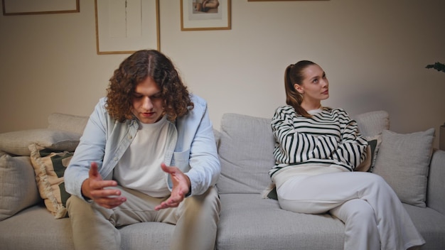 Frustrated couple arguing couch living room closeup offended woman separately