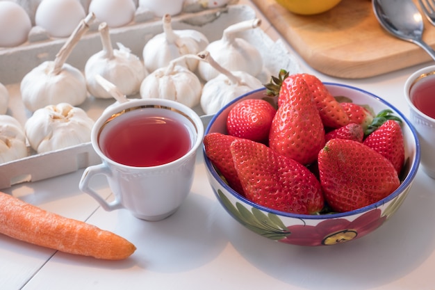 Frutta alla fragola con tè in ceramica stoviglie sul tavolo da pranzo