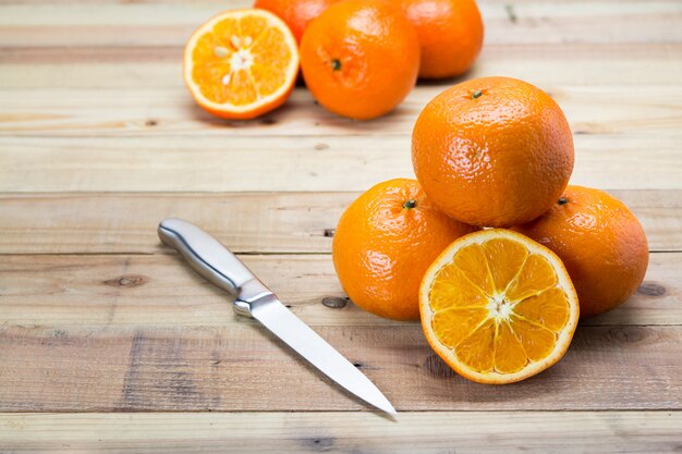 Frutta arancio sulla tavola di legno con il coltello