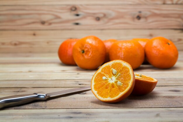 Frutta arancio sulla tavola di legno con il coltello