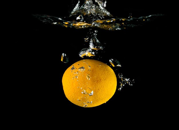 Frutta arancione che cade in acqua. elemento di design