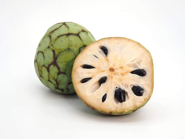 Frutta Cherimoya Annona cherimola tagliata a metà e intera su sfondo bianco