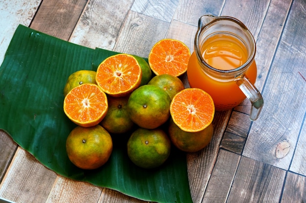 Frutta d'arancia fresca e succo d'arancia su un tavolo di legno