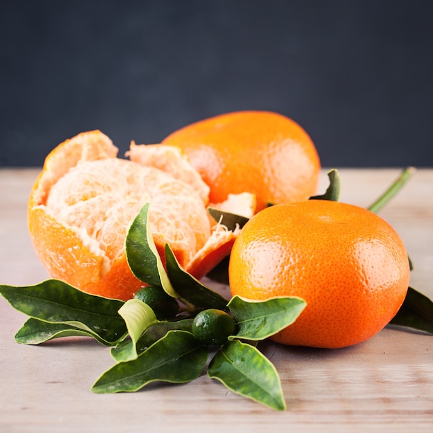 Frutta del mandarino arancio sul fondo rustico della tavola di legno