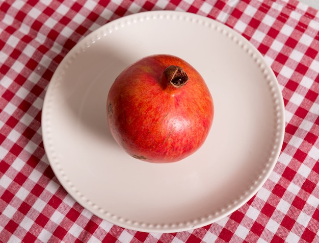 Frutta del melograno in un piatto bianco