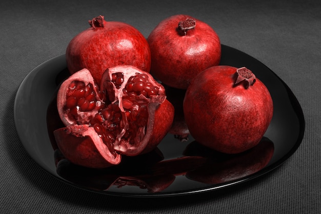 Frutta del melograno presentata su una banda nera
