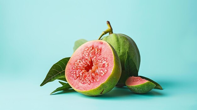 Frutta di guava fresca con foglie su uno sfondo blu La guava è tagliata a metà mostrando la carne e i semi rosa