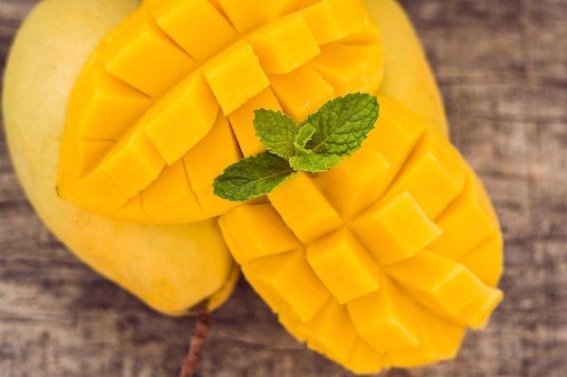 Frutta di mango e cubi di mango sul tavolo di legno