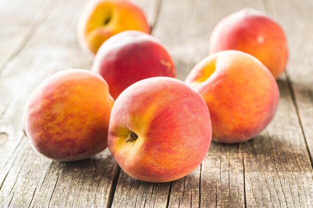 Frutta dolce delle pesche sulla vecchia tavola di legno