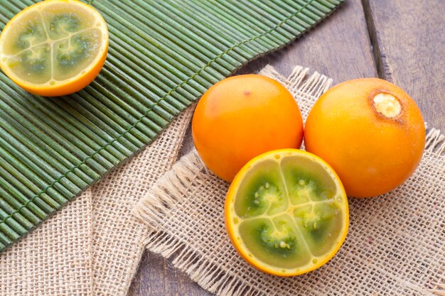 Frutta e fette di lulo o naranjilla sul tavolo di legno Solanum quitoense