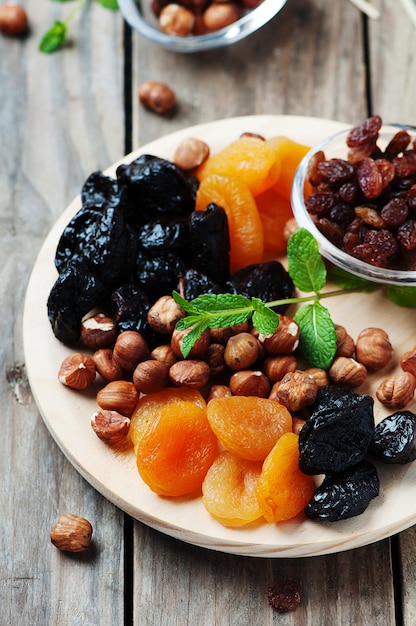 Frutta e noci secche sul vassoio di legno