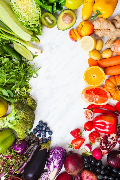 Frutta e verdura color arcobaleno su un tavolo bianco Concetto di alimentazione sana Un concetto di consegna di prodotti agricoli Cornice di cibo sano vista dall'alto