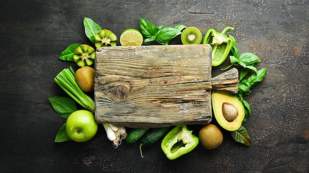 Frutta e verdura fresca verde Pura selezione e fonte di proteine vegetali su fondo in legno invecchiato Avocado uva cetrioli mele kiwi pepe verde lime