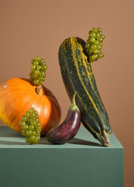 Frutta e verdura natura morta Zucchine zucca melanzane e uva sopra il tavolo verde Idea di natura visiva