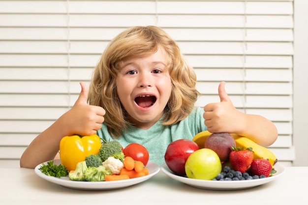 Frutta e verdura Ragazzo del capretto che mangia verdura sana dell'alimento Colazione con frutta e verdura del latte Bambino che mangia durante il pranzo o la cena