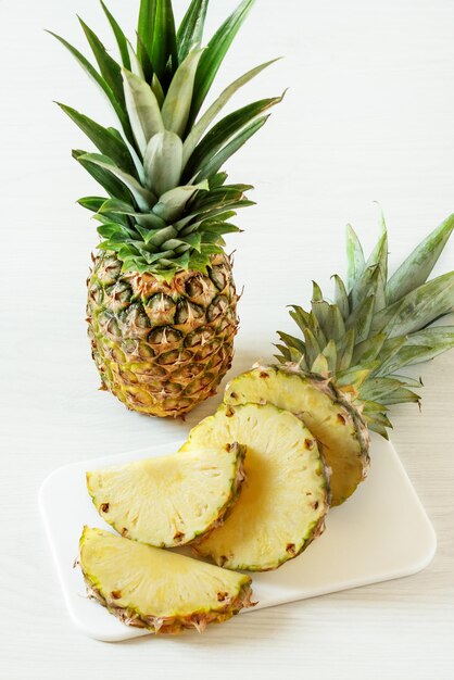 Frutta fresca di ananas affettata su fondo di legno bianco Vitamine mangiare sano