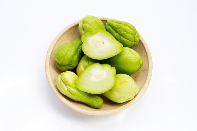 Frutta fresca di chayote nel piatto su sfondo bianco.