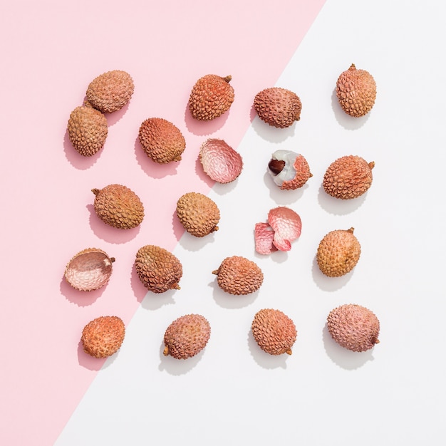 Frutta fresca di litchi su superficie bianca rosa pastello