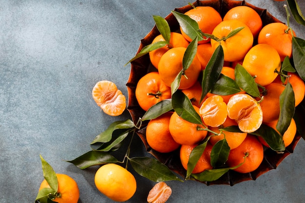 Frutta fresca di mandarini o mandarini con foglie in scatola di legno, vista dall'alto