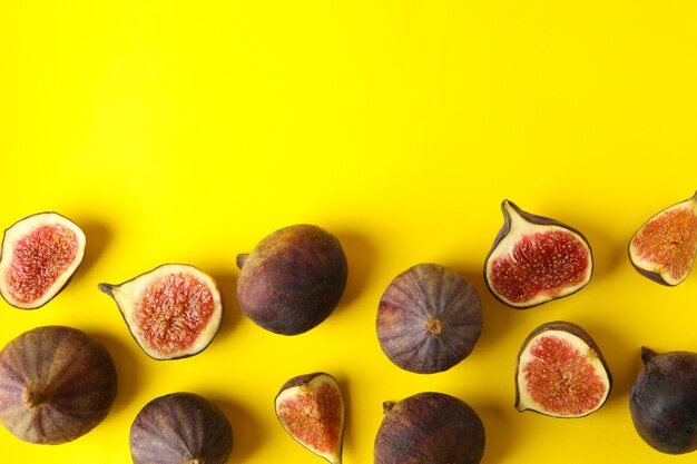 Frutta fresca e fette di fico su giallo, vista dall'alto