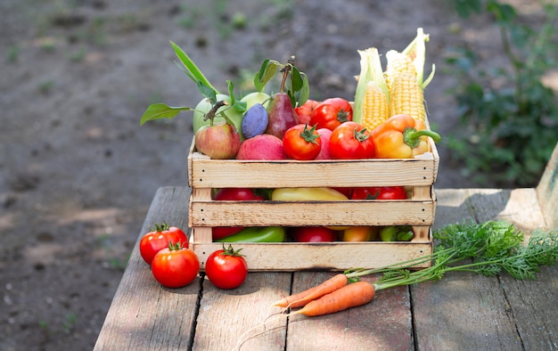 Frutta fresca e verdura in cassa su fondo di legno rustico all'aperto