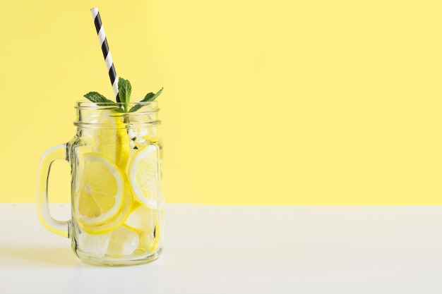 Frutta fresca estiva acqua o limonata con limone e menta. Avvicinamento.