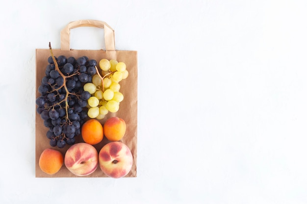 Frutta fresca sul sacchetto di carta, concetto di cibo sano e zero sprechi, sfondo bianco, spazio copia, vista dall'alto