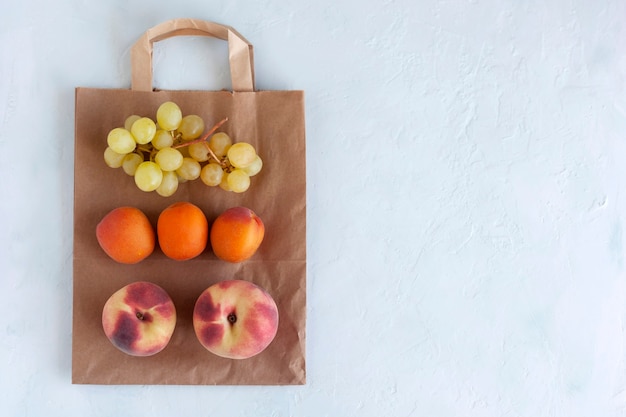 Frutta fresca sul sacco di carta, zero sprechi e concetto di cibo sano, sfondo bianco, spazio copia, vista dall'alto