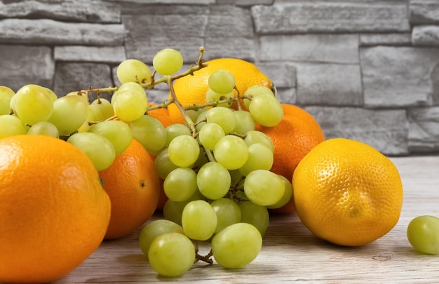 Frutta fresca sul tavolo arance limoni uva su un tavolo di legno foto