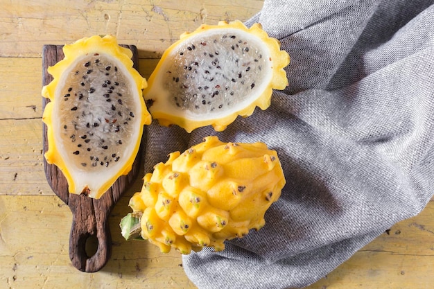 Frutta gialla del drago pitahaya su fondo di legno